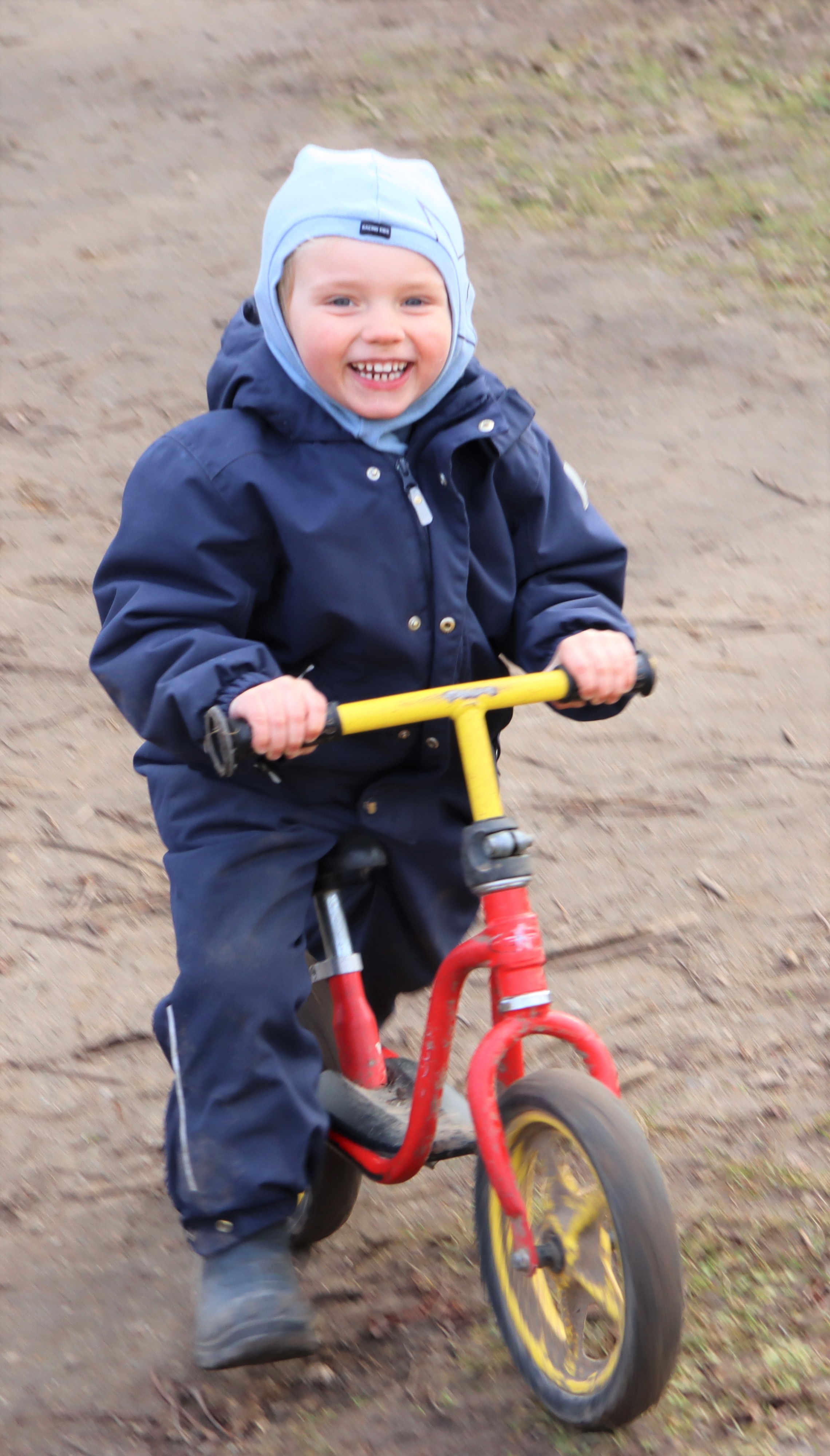 Dreng cykler og smiler